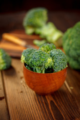 Broccoli crowns in a wooden bowl over table.