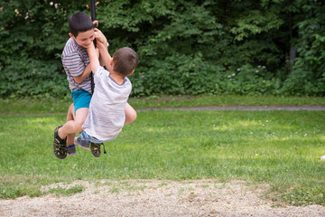 Children playing in park on zip line swing