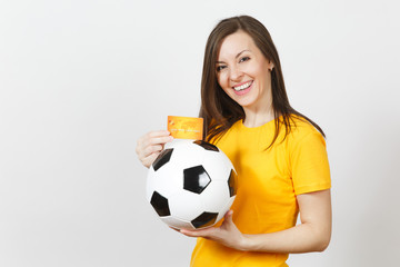 Beautiful European young cheerful woman, football fan or player in yellow uniform holding credit card soccer ball isolated on white background. Sport, play football game, excitement lifestyle concept.