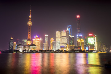 Fototapeta na wymiar The lights of Shanghai, China reflect off the Huangpu River in a Downtown area known as The Bund.