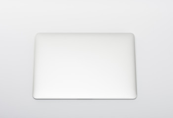 Closed  modern, new laptop on white background, top view.