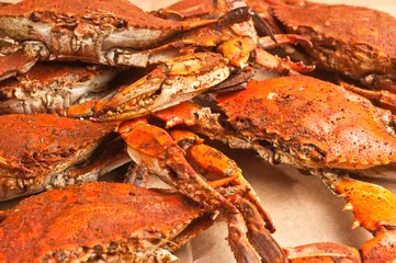 Foto op Canvas steamed blue claw crabs / Top view of  five freshly steamed blue claw crabs covered with spicy old bay seasoning, cooling on a sheet of brown paper © reve15