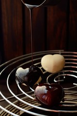 Process of pouring chocolate glaze on heart shape form  dessert