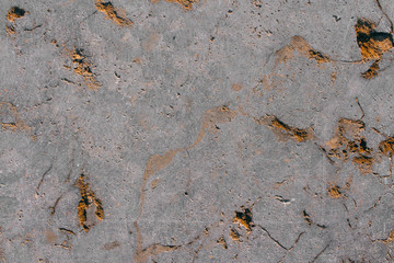 The texture of a natural gray stone with golden impregnations. Copy space stone background.