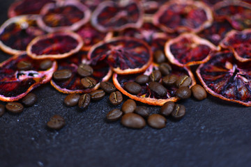 Dried red orange slices with a coffee beans on a stone background. Beautiful and tasty background for design.