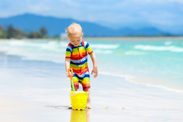 Kids play on tropical beach. Sand and water toy.