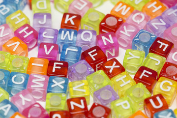 Colorful plastic beads with letters isolated on a white background.