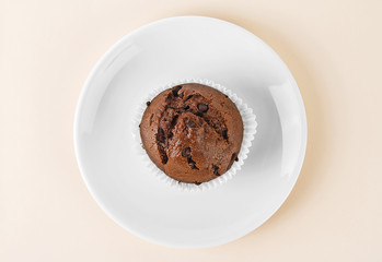 Chocolate muffin on white plate. Top view.