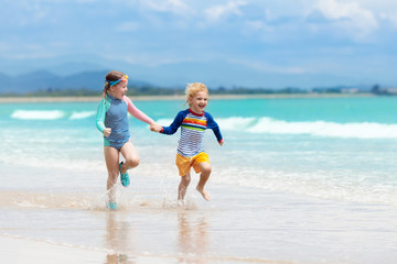 Kids on tropical beach. Children playing at sea.