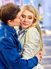 Fototapeta premium Spring couple walking park and kissing. Summer friends walk outdoor. First date of two young people in good weather day. Tone image with backlit shiny background sunset. Meeting after long separation.