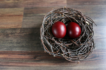 Easter eggs in the nest on wooden background