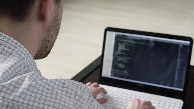 Programmer at work. Software Developer. Man coding on the laptop.  IT sphere.