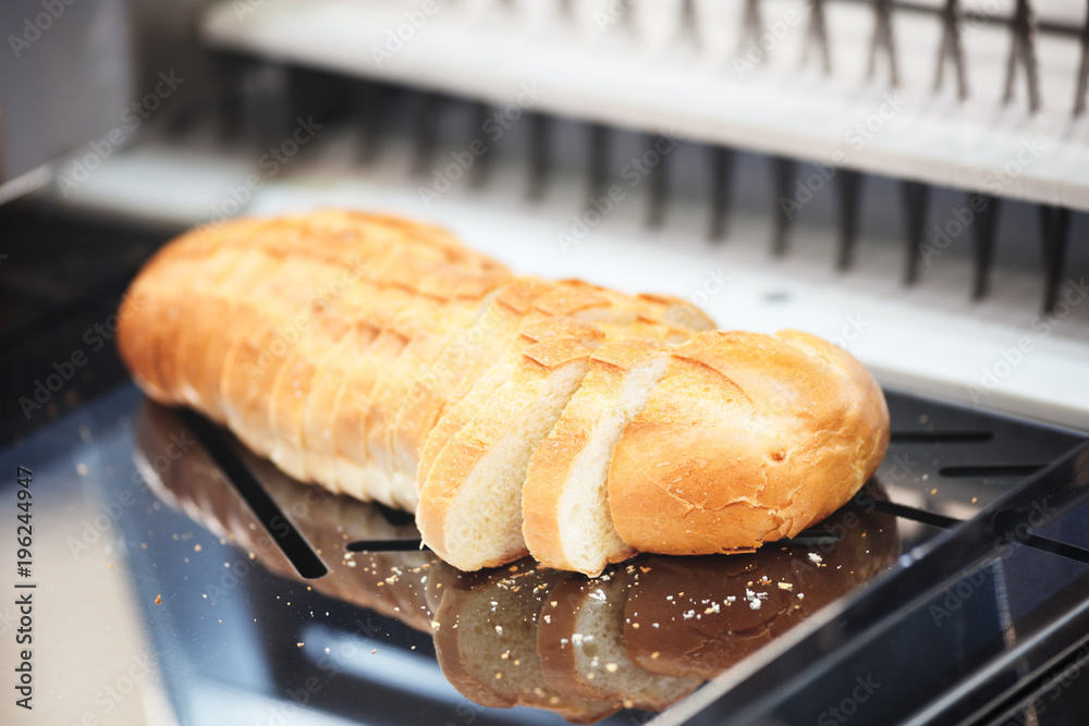 Poster fresh sliced white bread on breadslicer machine