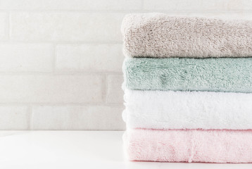 Spa relax and bath concept, stack clean bath towels colorful cotton terry textile in bathroom white background, copy space top view - obrazy, fototapety, plakaty