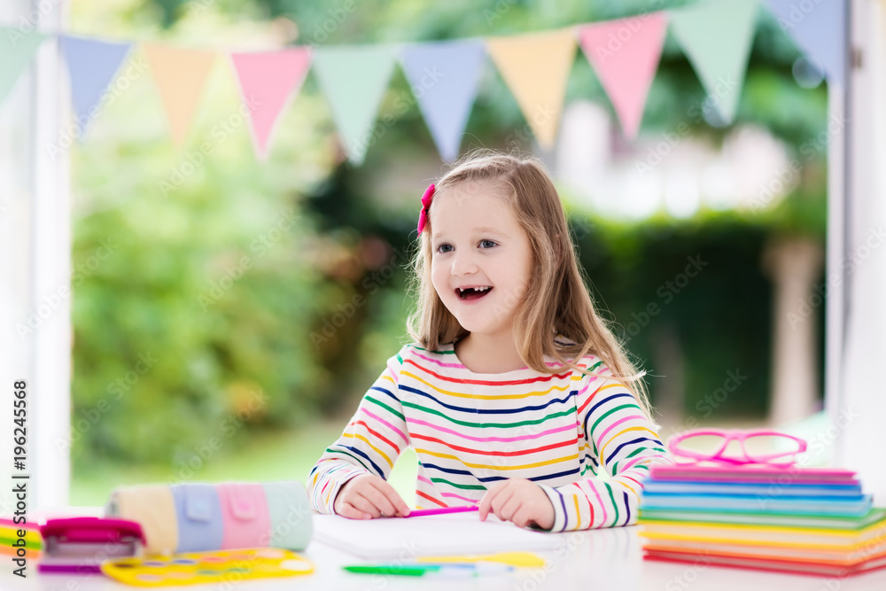 Wall mural Child doing homework for school. Kids learn and paint.