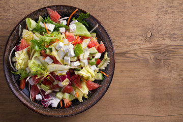 Grapefruit, tomato, lettuce and cucumber salad with feta cheese. Clean eating, healthy and diet food concept. View from above, top