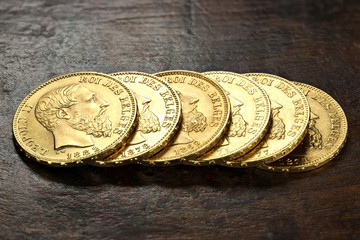 Belgian 20 Francs gold coins on rustic wooden background