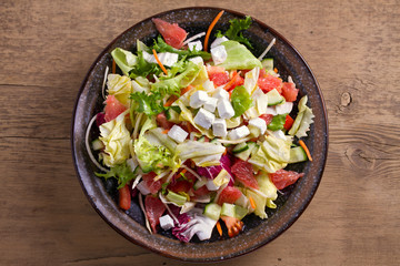 Grapefruit, tomato, lettuce and cucumber salad with feta cheese. Clean eating, healthy and diet food concept. View from above, top
