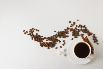 White cup with coffee, coffee beans on a white background. Flat lay, top view