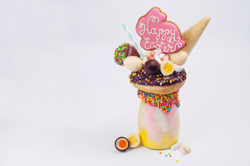 Easter freak shake decorated with Easter bunny gingerbread on light background
