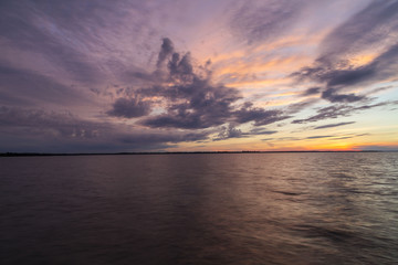 Fototapeta na wymiar Dramatic clouds at sunset on a calm lake