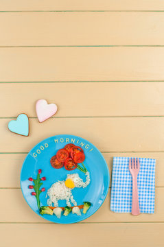 Funny elephant with ballons from rice and fresh vegetables on wooden background