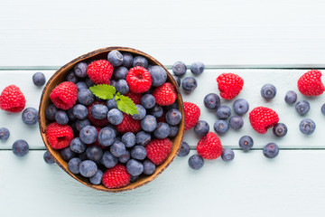 Juicy and fresh blueberries with green mint on rustic blue table.
