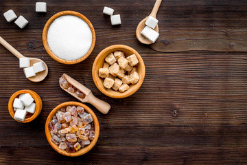 Sugar types. Cane, refind, granulated, cubes, candy sugar. Dark wooden background top view copy space