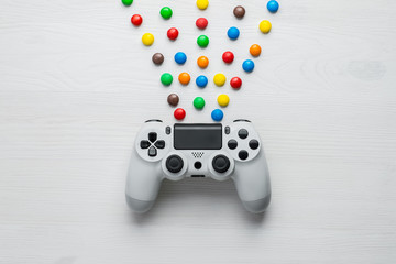 white modern gamepad and multicolored candy on white