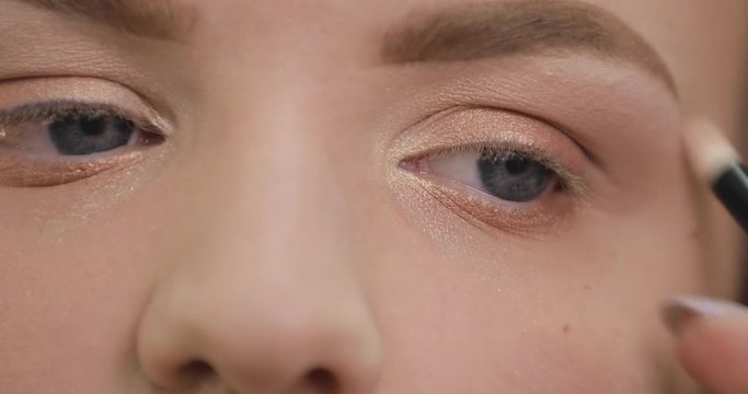 Painting eye with brown eyeshadows, makeup closeup