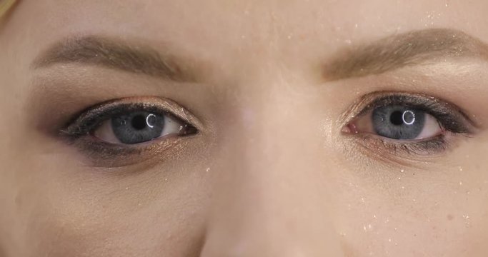 Close up of woman open her wet eyes, pupils rapidly narrows