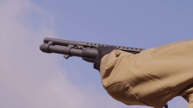 Male training with shotgun  outdoors in field. Hunter with rifle, 
