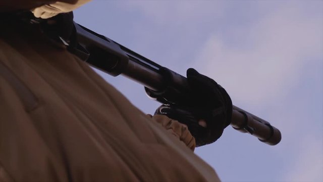 Male training with shotgun  outdoors in field. Hunter with rifle, 