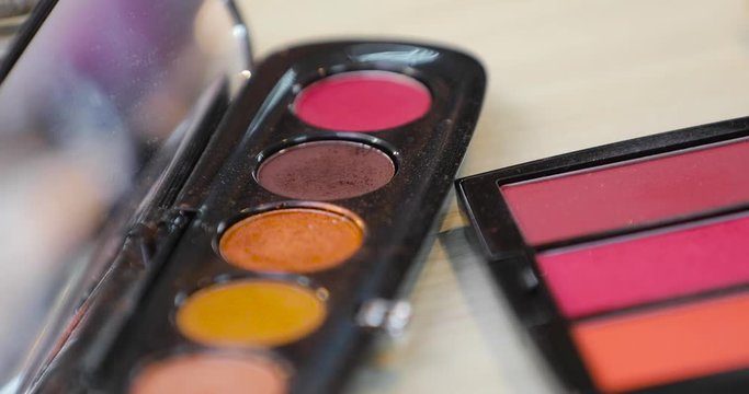 Dipping brush in eye shadows, decorative cosmetics for makeup closeup