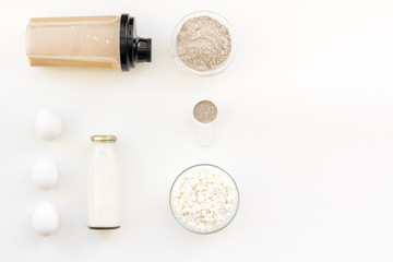 sport nutrition set with protein powder for cocktail, eggs and milk white background top view space for text