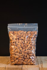 Almond in a zipper bag on wood table.