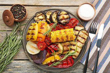 Grilled vegetable on brown cutting board with rosemary, salt and pepper
