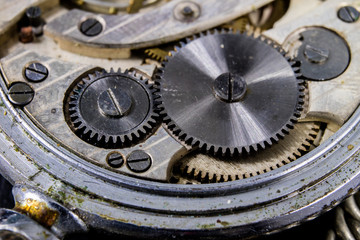 Fototapeta na wymiar An old watch on a dark table. Timer mechanism seen enlarged.