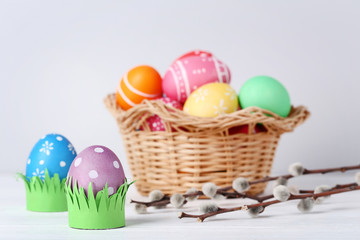 Colorful easter eggs in basket on grey background