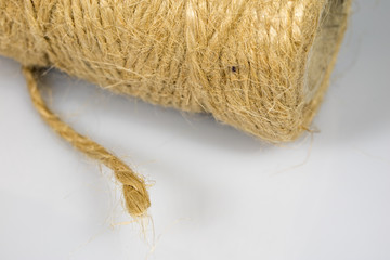 Jute twine rolled up in cradle. Accessories for packing postal parcels on an isolated background.