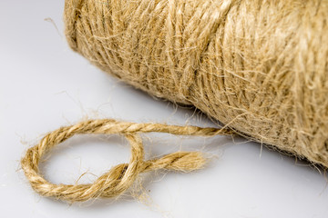 Jute twine rolled up in cradle. Accessories for packing postal parcels on an isolated background.