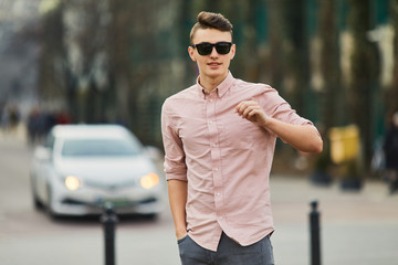 Fototapeta premium Young boy walking on the city street wear glasses and smile to the camera