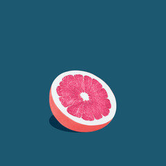 Grapefruit in pop art style Half of grapefruit with pink pulp is lying on a dark blue background Trendy photo with text space