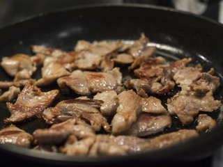 Kebab/bacon frying on a greasy pan