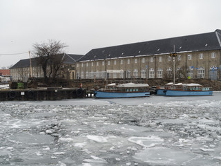 Copenhagen harbor frozen with small blue boats caought in the ice