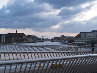 Copenhagen Canal/harbor cut buy a bike bridge, with dramtic clouds.