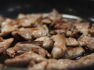 Kebab/bacon frying on a greasy pan