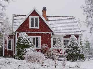 Snow covered red cabin in the swedish woods
