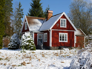 Snow covered red cabin in the swedish woods