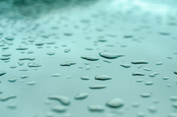 texture of a drop of water on a green glossy surface